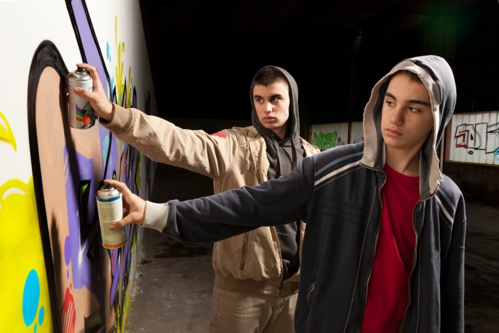 teens spraying painting restaurant wall