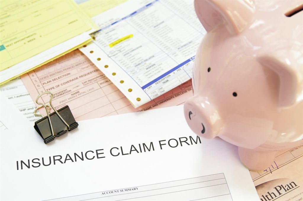 piggy bank next to insurance claim form