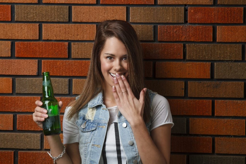 underage female drinking beer at a bar